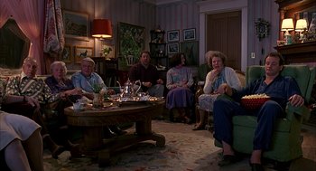 Movie still from “Groundhog Day” (1993), directed by Harold Ramis – A group of people sitting around a living room; Wide shot, High angle
