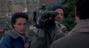 Movie still from “Groundhog Day” (1993), directed by Harold Ramis – A man and a woman with a video camera in front of a tree; Close Up shot, Over the shoulder angle
