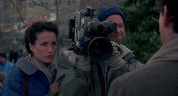 Movie still from “Groundhog Day” (1993), directed by Harold Ramis – A man and a woman with a video camera in front of a tree; Close Up shot, Over the shoulder angle