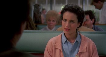 Movie still from “Groundhog Day” (1993), directed by Harold Ramis – A woman sitting in front of other people in a car; Close Up shot, Over the shoulder angle