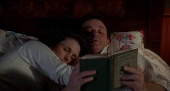 Movie still from “Groundhog Day” (1993), directed by Harold Ramis – A man and a woman reading a book in bed; Medium shot, Overhead angle