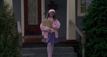 Movie still from “Groundhog Day” (1993), directed by Harold Ramis – A young girl dressed as a little girl reading a book; Wide shot, High angle