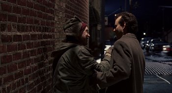 Movie still from “Groundhog Day” (1993), directed by Harold Ramis – Two men standing next to each other on a sidewalk; Medium shot, Over the shoulder angle