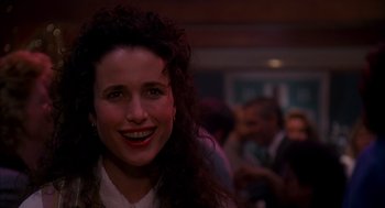 Movie still from “Groundhog Day” (1993), directed by Harold Ramis – A person smiling at a party; Close Up shot, Over the shoulder angle