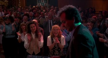 Movie still from “Groundhog Day” (1993), directed by Harold Ramis – A group of people standing in front of an audience; Medium shot, High angle
