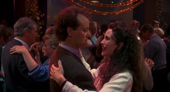 Movie still from “Groundhog Day” (1993), directed by Harold Ramis – A man and a woman are dancing together; Close Up shot, Over the shoulder angle