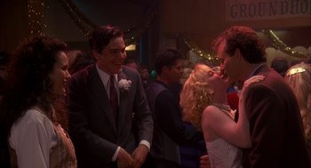 Movie still from “Groundhog Day” (1993), directed by Harold Ramis – A group of young people dancing together at a party; Medium shot, Over the shoulder angle