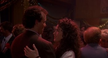 Movie still from “Groundhog Day” (1993), directed by Harold Ramis – A man and a woman dancing together in a room; Close Up shot, Over the shoulder angle