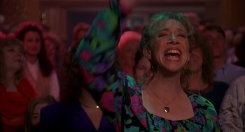 Movie still from “Groundhog Day” (1993), directed by Harold Ramis – A group of people that are standing in a room together; Medium shot, Low angle