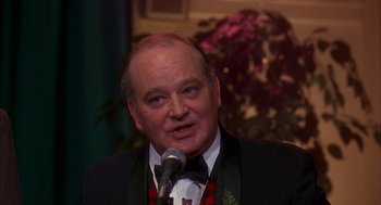 Movie still from “Groundhog Day” (1993), directed by Harold Ramis – A person wearing a suit and a bow tie; Close Up shot, Over the shoulder angle