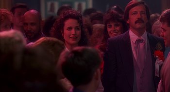 Movie still from “Groundhog Day” (1993), directed by Harold Ramis – A group of people standing around a room together; Medium shot, Over the shoulder angle