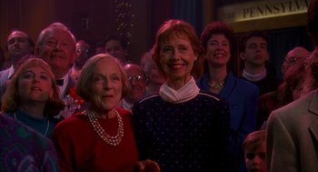 Movie still from “Groundhog Day” (1993), directed by Harold Ramis – A group of people standing in front of a crowd of people; Medium shot, High angle