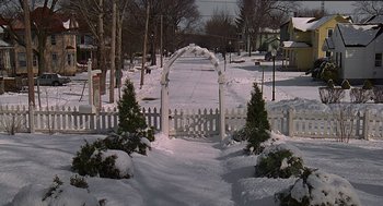 Movie still from “Groundhog Day” (1993), directed by Harold Ramis – A white arbor in the middle of a snow covered yard; Extreme Wide shot, High angle