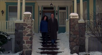 Movie still from “Groundhog Day” (1993), directed by Harold Ramis – A man and a woman are standing on the steps of a house; Wide shot, Low angle