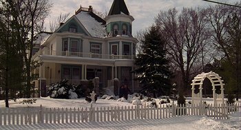 Movie still from “Groundhog Day” (1993), directed by Harold Ramis – A house with a picket fence in front of it; Extreme Wide shot, Low angle