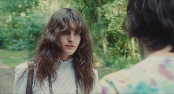 Movie still from “Something in the Air” (2012), directed by Olivier Assayas – A woman with long brown hair wearing a white shirt; Close Up shot, Over the shoulder angle