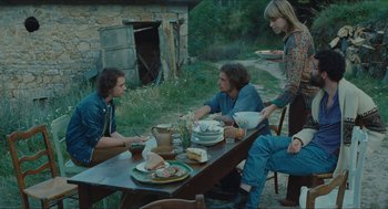 Movie still from “Something in the Air” (2012), directed by Olivier Assayas – A group of people sitting at a table outside; Wide shot, High angle