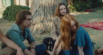 Movie still from “Something in the Air” (2012), directed by Olivier Assayas – A group of young people sitting next to each other; Medium shot, Over the shoulder angle