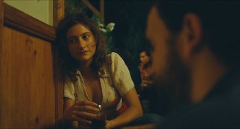 Movie still from “Something in the Air” (2012), directed by Olivier Assayas – A woman sitting in front of a man holding a drink; Close Up shot, Over the shoulder angle