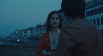 Movie still from “Something in the Air” (2012), directed by Olivier Assayas – A woman standing next to a man on a street; Medium shot, Over the shoulder angle