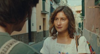 Movie still from “Something in the Air” (2012), directed by Olivier Assayas – A young woman standing next to a man on the street; Close Up shot, Over the shoulder angle