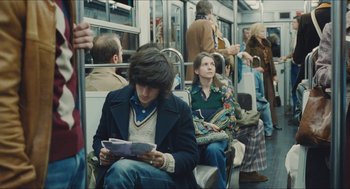 Movie still from “Something in the Air” (2012), directed by Olivier Assayas – A group of people riding on a train; Medium shot, Over the shoulder angle