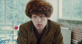 Movie still from “Something in the Air” (2012), directed by Olivier Assayas – A young man with a brown jacket and curly hair; Close Up shot, Low angle