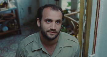 Movie still from “Something in the Air” (2012), directed by Olivier Assayas – A person with a beard; Close Up shot, High angle