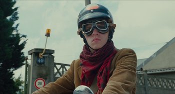 Movie still from “Something in the Air” (2012), directed by Olivier Assayas – A person wearing goggles and a helmet on a motorcycle; Close Up shot, Low angle
