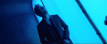 Movie still from “Song to Song” (2017), directed by Terrence Malick – A man in a black suit is laughing; Medium shot, Low angle