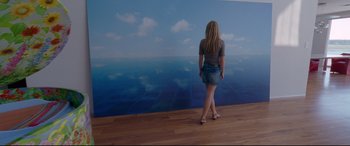 Movie still from “Song to Song” (2017), directed by Terrence Malick – A woman standing in front of an ocean mural; Wide shot, High angle