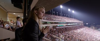 Movie still from “Song to Song” (2017), directed by Terrence Malick – A beautiful blonde woman standing in front of a crowd; Medium shot, Over the shoulder angle