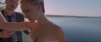 Movie still from “Song to Song” (2017), directed by Terrence Malick – A woman wearing a white dress and a necklace on a body of water; Close Up shot, Low angle