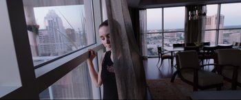 Movie still from “Song to Song” (2017), directed by Terrence Malick – A beautiful young lady standing in front of a window; Medium shot, Low angle
