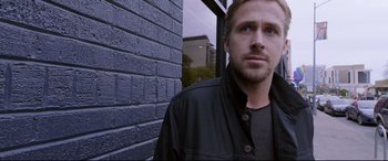 Movie still from “Song to Song” (2017), directed by Terrence Malick – A person standing near a brick wall; Close Up shot, Over the shoulder angle