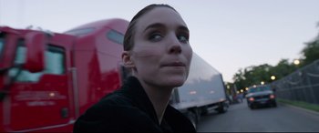 Movie still from “Song to Song” (2017), directed by Terrence Malick – A person wearing a black shirt near a red truck; Close Up shot, Low angle