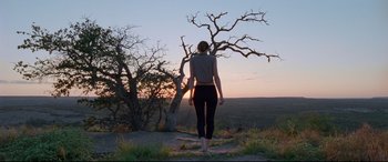 Movie still from “Song to Song” (2017), directed by Terrence Malick – A woman standing on top of a grass covered hill; Wide shot, Low angle