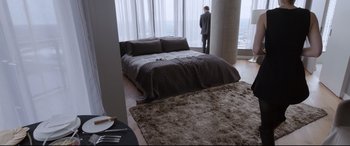 Movie still from “Song to Song” (2017), directed by Terrence Malick – A man standing in front of a bed in a bedroom; Wide shot, High angle