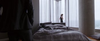 Movie still from “Song to Song” (2017), directed by Terrence Malick – A woman standing in front of a window in a bedroom; Wide shot, Over the shoulder angle