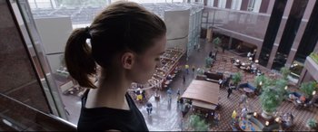Movie still from “Song to Song” (2017), directed by Terrence Malick – A woman standing in front of a building looking out the window; Medium shot, Over the shoulder angle