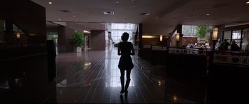 Movie still from “Song to Song” (2017), directed by Terrence Malick – A woman is walking down the hall of an office building; Wide shot, Low angle