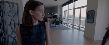Movie still from “Song to Song” (2017), directed by Terrence Malick – A woman standing in front of a large window in a living room; Medium shot, Low angle