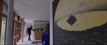 Movie still from “Song to Song” (2017), directed by Terrence Malick – Two people in a room with a painting on the wall behind them; Wide shot, High angle