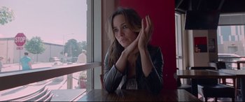 Movie still from “Song to Song” (2017), directed by Terrence Malick – A beautiful young lady sitting at a wooden table; Close Up shot, High angle