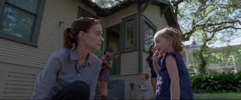 Movie still from “Song to Song” (2017), directed by Terrence Malick – A woman and a child standing in front of a house; Medium shot, Over the shoulder angle