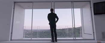 Movie still from “Song to Song” (2017), directed by Terrence Malick – A man standing in front of an open window; Wide shot, Low angle