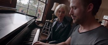 Movie still from “Song to Song” (2017), directed by Terrence Malick – A man and a woman sitting at a piano together; Medium shot, Over the shoulder angle