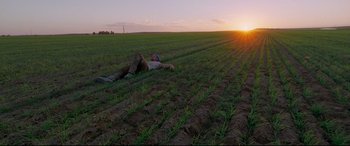 Movie still from “Song to Song” (2017), directed by Terrence Malick – A man laying in the middle of an open field; Extreme Wide shot, Low angle