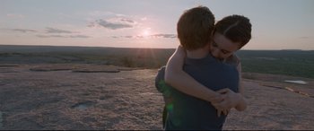 Movie still from “Song to Song” (2017), directed by Terrence Malick – A man and a woman hugging on top of a hill; Medium shot, Overhead angle