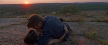 Movie still from “Song to Song” (2017), directed by Terrence Malick – A man and a woman kissing on the side of a hill; Medium shot, Low angle
